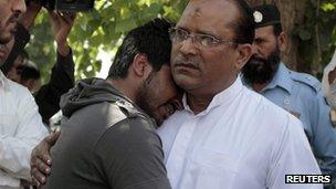 Chaudhry Zulfikar Ali's son, Qamar Abbas (left) mourns his father