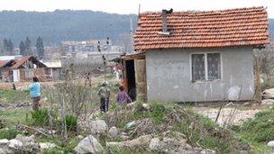 Children play beside a run-down home on a Roma settlement in Bulgaria.