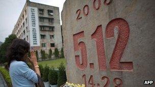 A woman places flowers and mourns for the victims who died in the earthquake at a memorial park at the Beichuan town in Sichuan province on 24 April 2013 in Chengdu, China