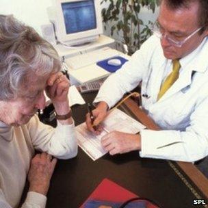 GP writing a prescription for a patient