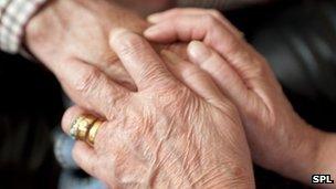 Carer holding elderly person's hand