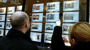 Generic couple looking at estate agent window