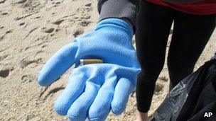 Woman on beach holding cigarette butt