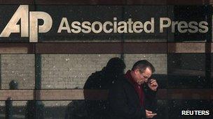 Man looks at his phone outside the offices of the Associated Press in Manhattan, New York (13 May 2013)