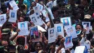 People hold up pictures of their missing relatives in Savar, near Dhaka. Photo: 14 May 2013