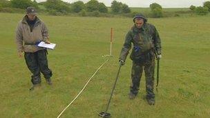 Metal detector searches on battlefield site