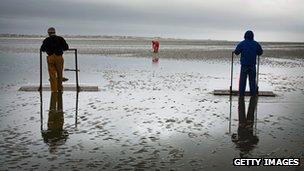 People using boards to walk on Morecambe bay sands