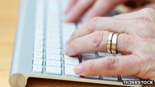 An old lady's hands on a computer keyboard