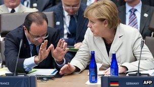 A file picture taken on 21 May, 2012 shows French President Francois Hollande (left) speaking with German Chancellor Angela Merkel during a meeting with partner nations in Chicago