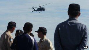 An S70-C helicopter flies over officers and crew on a Kidd-class destroyer during exercises off the southern city of Kaohsiung, Taiwan 16 May 2013