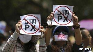 Demonstrators hold up sheets of paper which read "Kunming PX" at a protest in Kunming on 16 May 2013