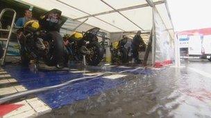 Racers shelter from heavy rain at the NW200