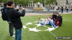 Football fans take photographs in a football fan zone in Trafalgar Square, central London, ahead of the Champions League final on Saturday