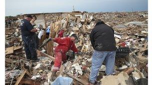 Residents sift through debris of a ruined home