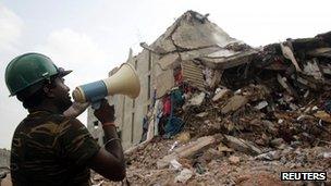 A rescue worker attempts to find survivors within the rubble of the collapsed Rana Plaza building in Savar, 30 km (19 miles) outside Dhaka