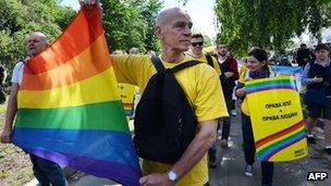 Activists carry a rainbow flag during a gay pride march in Kiev. Photo: 25 May 2013