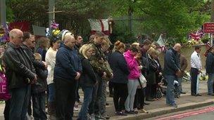 Members of the public observe a minute's silence in Woolwich