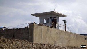 A North Korean soldier stands guard on the banks of the Yalu River at the North Korean town of Sinuiju across from the Chinese city of Dandong on 10 April 2013