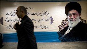 An Interior Ministry security officer walks past a portrait of supreme leader Ayatollah Ali Khamenei during registeration of candidates for the upcoming presidential election