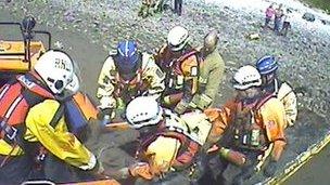 the girl being lifted into the hovercraft on a stretcher