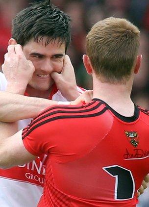 Derry defender Chrissy McKaigue clashes with Down forward Benny Coulter