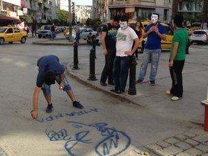 Protesters draw a graffito of PM Erdogan