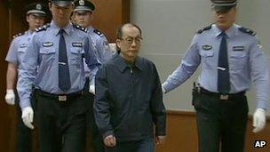 Former Chinese Railways Minister Liu Zhijun, second from right, is escorted into a courtroom in Beijing on 9 June 2013