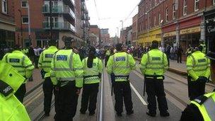 Police in a line in front of protestors