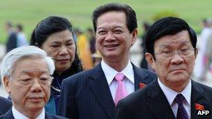 Prime Minister Nguyen Tan Dung (second on the right) smiling as he walks behind Vietnamese communist party Secretary General Nguyen Phu Trong (left) and President Truong Tan Sang (right) in October 2012