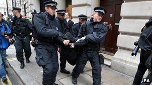 Police restrain a protester in Soho