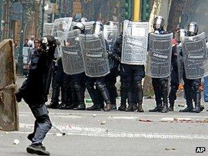 A demonstrator hurls stones at police in central Genoa during protests against the G8 summit on 20 July 2001