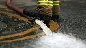 A fire fighter pumps out flood water