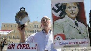 A Greek protester holds a poster of Angela Merkel