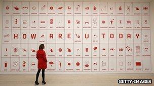 An employee looks at artist Justin Wong's 'Difficult Life Station' at the 'Hong Kong Eye' exhibition at Saatchi Gallery on December 4