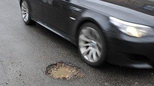 Car passes pothole