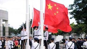 The Hong Kong (L) and Chinese flags (R) are released during a flag-raising ceremony at Golden Bauhinia Square in Hong Kong on 1 July 2013 to celebrate the 16th anniversary of the handover