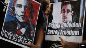 Protesters hold pictures of President Barack Obama, left, and Edward Snowden during a demonstration outside the Consulate General of the United States in Hong Kong 15 June 2013