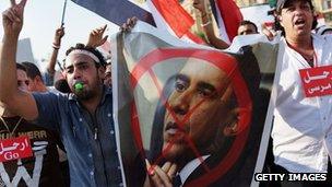 People carry anti-Obama posters as thousands of Egyptian protesters celebrate in Tahrir Square as the deadline given by the military to Egyptian President Mohammed Morsi passes 3 July 2013