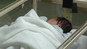 Baby in hospital cot