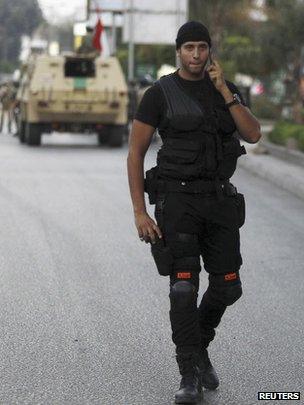 A police special forces member walks near army soldiers taking positions in front of protesters who are against Egyptian President Morsi, near the Republican Guard headquarters in Cairo (3 July 2013)