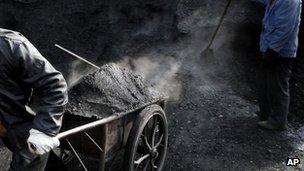 Chinese worker pulls a cart full of coal to deliver them to a heating station. File photo