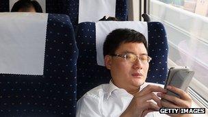 Man uses smartphone on train in China