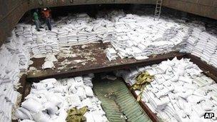 Panamanian workers stand atop sacks of sugar inside a North Korean-flagged ship