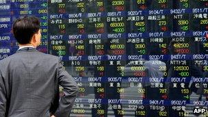 An investor looking at a stock market board in Japan