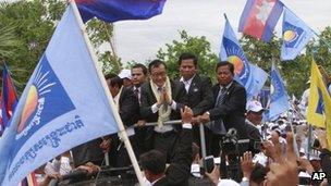 Sam Rainsy, centre, greets his supporters on arrival in Phnom Penh, Cambodia, on 19 July 2013