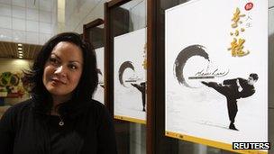 Shannon Lee, daughter of the late Kung Fu legend Bruce Lee, poses with a poster of her father at the Hong Kong Heritage Museum before the start of a five-year exhibition on Lee, 18 July 2013