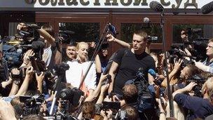 Russian opposition leader Alexei Navalny (R, centre) talks to the media, with his wife Yulia (L, centre) standing nearby, outside a court building in Kirov