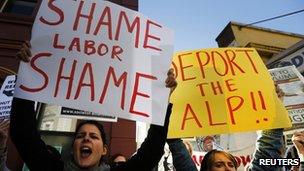 Women hold posters bearing messages against the Australian Labor Party (ALP) during a rally in support of asylum seekers outside an ALP meeting in Sydney 22 July 2013