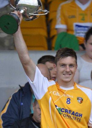 Antrim captain Jackson McGreevy lifts the cup after the win over Derry