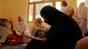 A woman in a burqa sitting down